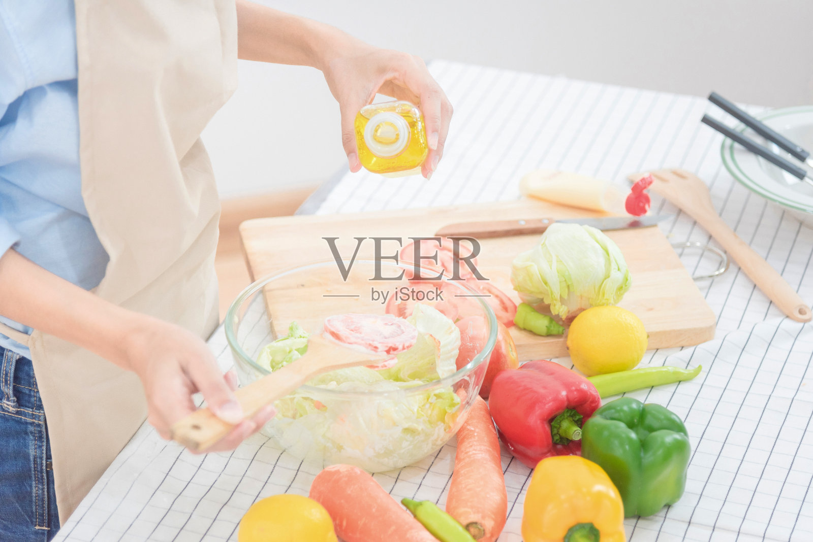 年轻的亚洲妇女在家准备健康的食物沙拉照片摄影图片