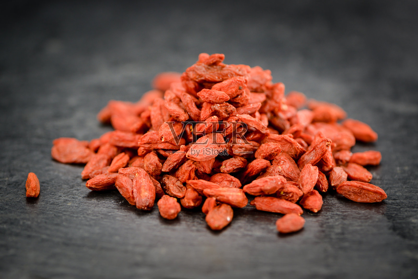 一些枸杞(干)在黑色石板上照片摄影图片