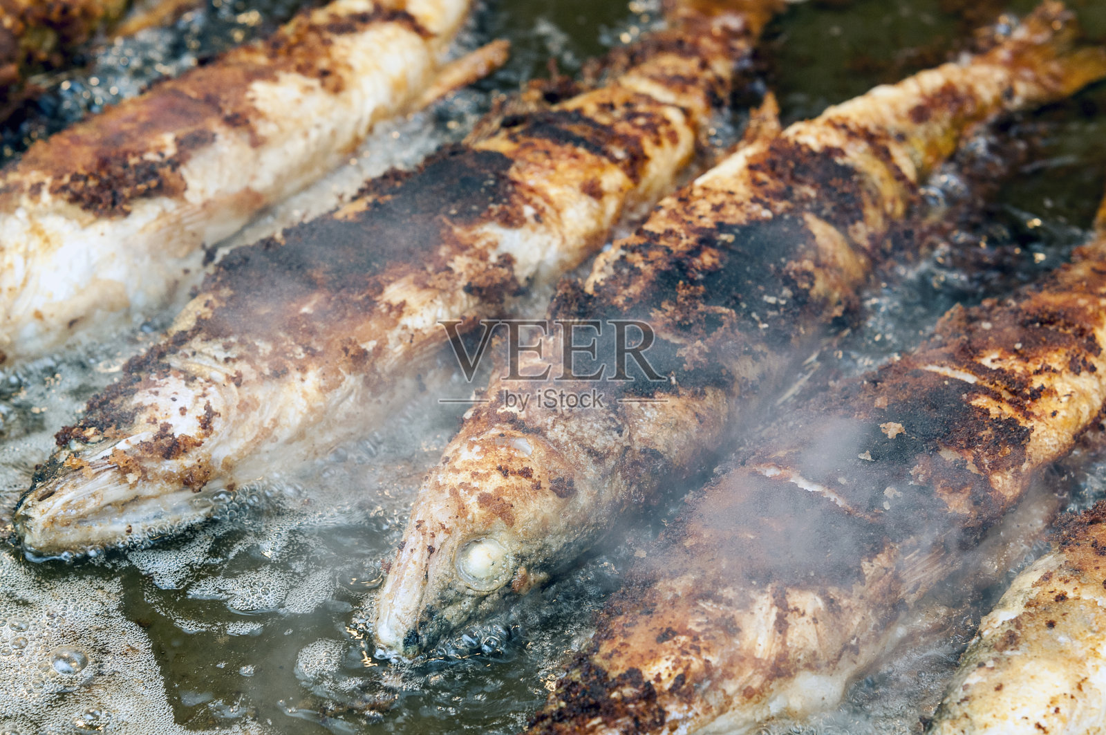 整条炸鱼挨着一条照片摄影图片