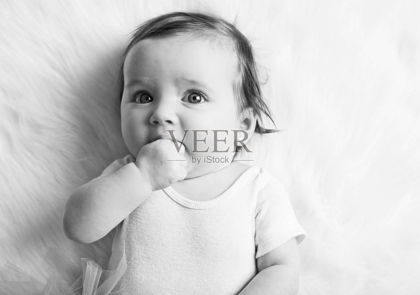 可爱的小女孩的手在她的嘴照片摄影图片