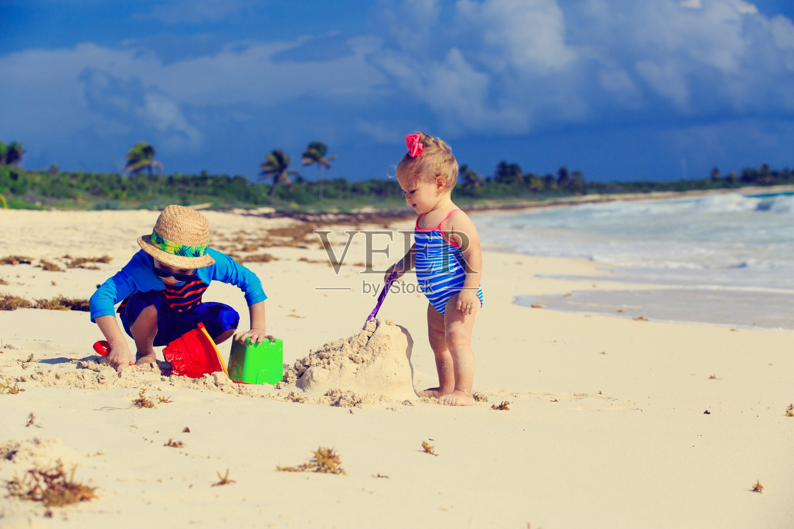 小男孩和小女孩在热带海滩上玩耍照片摄影图片