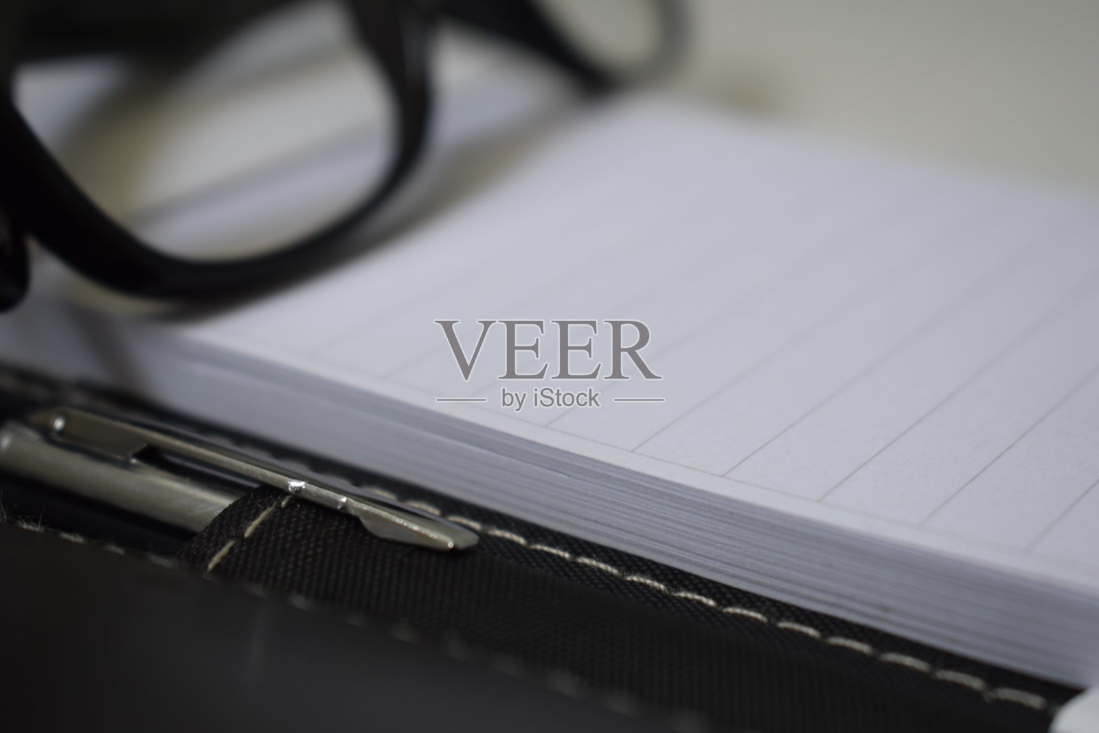 办公室的桌子上有眼镜和钢笔照片摄影图片