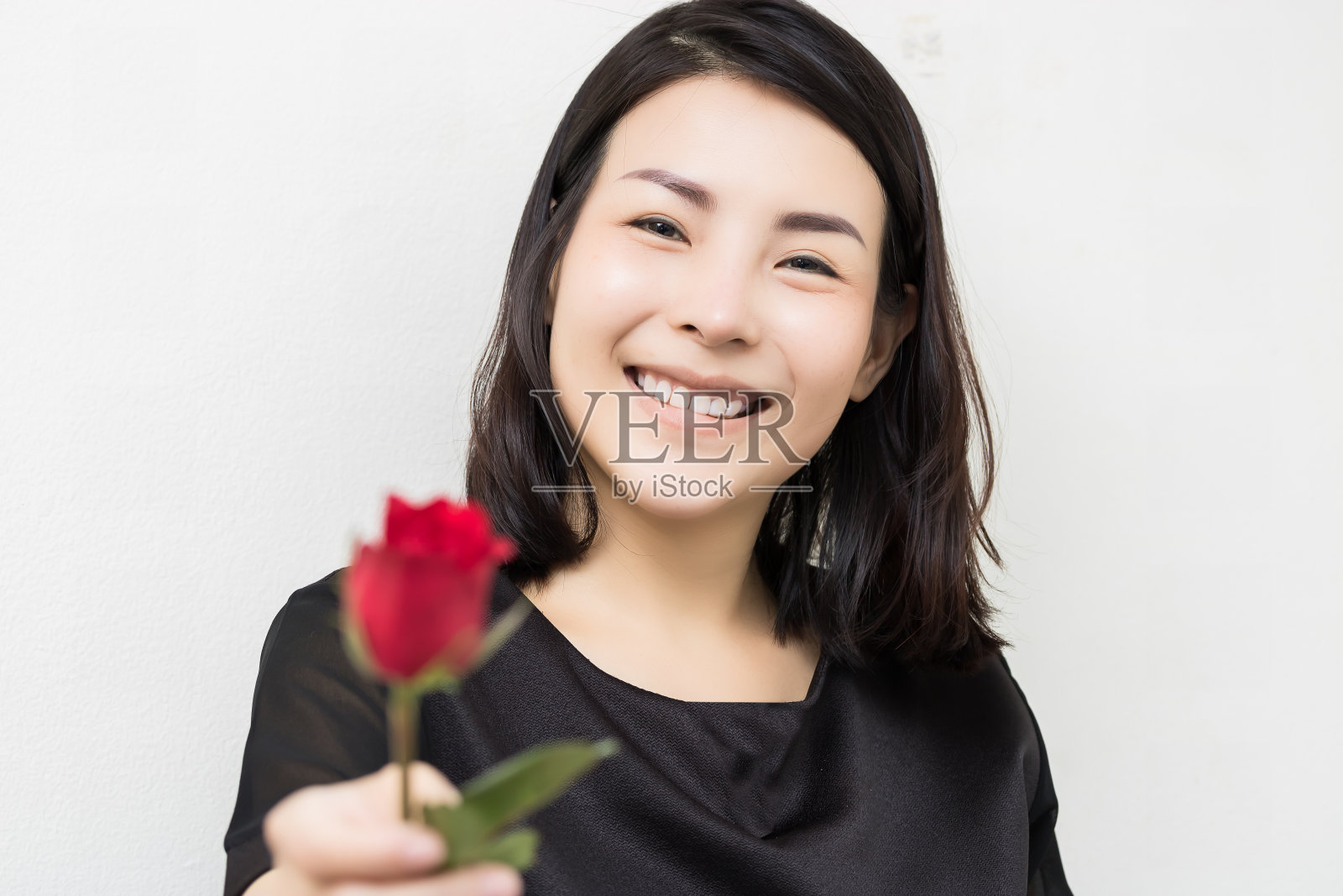 女人手里握着红玫瑰。情人节的概念全在爱里照片摄影图片