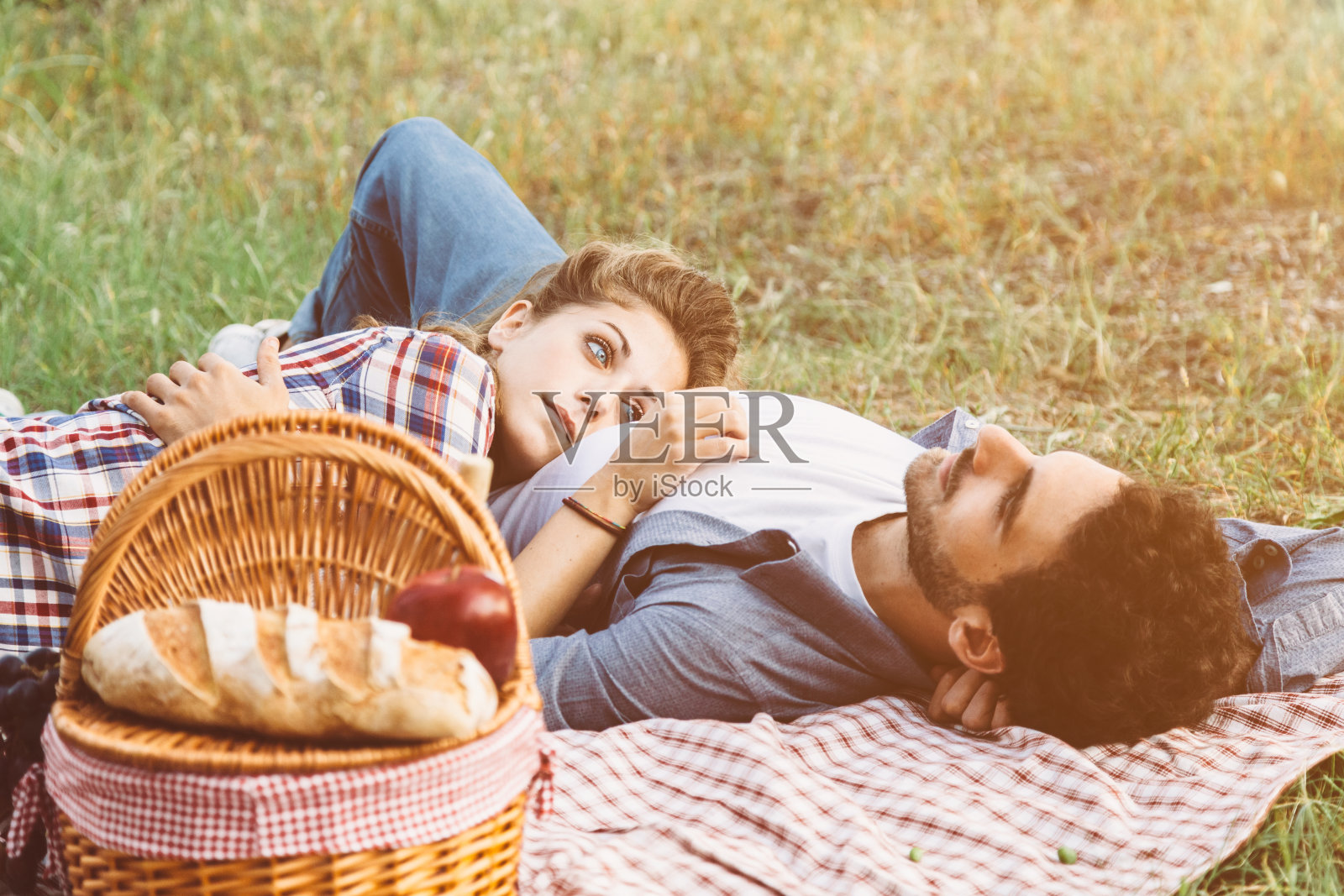 一对恋人躺在草地上照片摄影图片