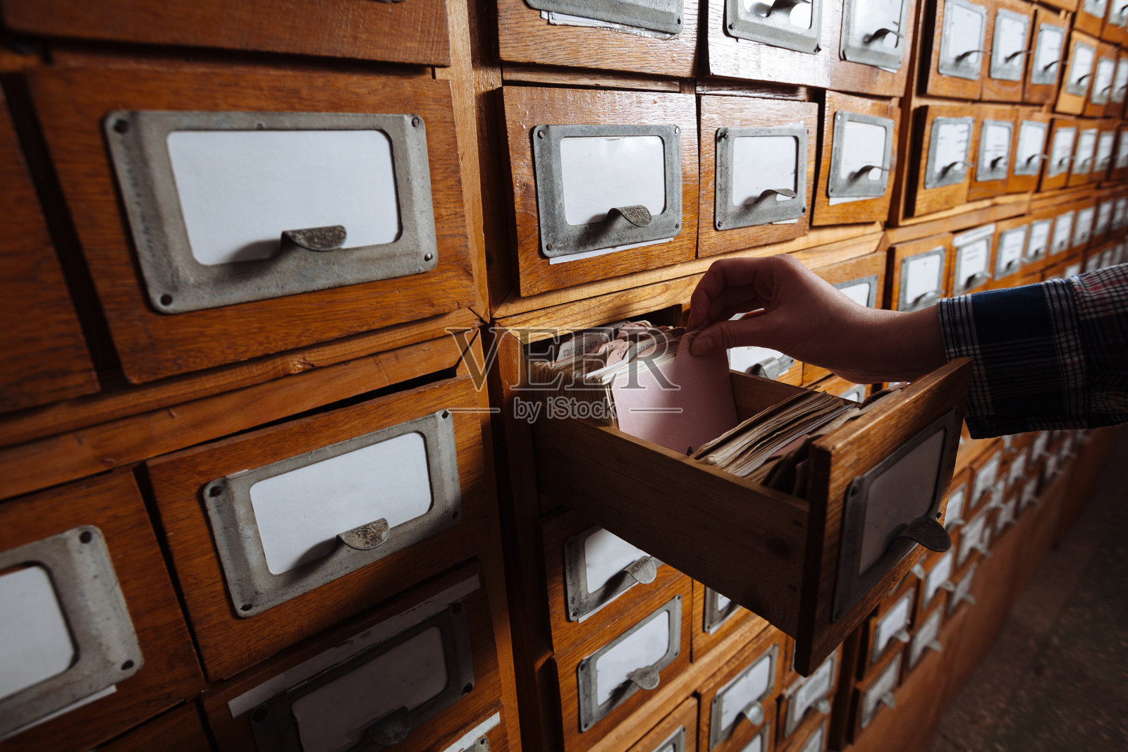 女人用手打开装满文件的文件柜抽屉照片摄影图片