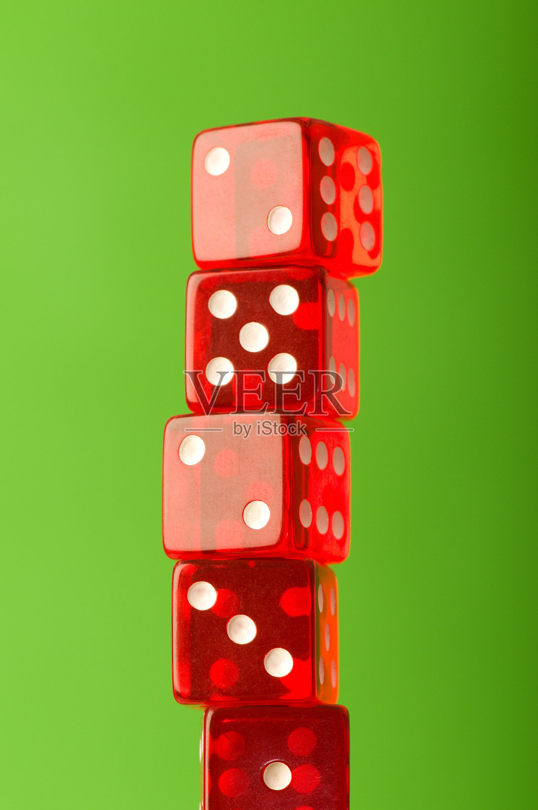 红色骰子堆在模糊的绿色背景照片摄影图片