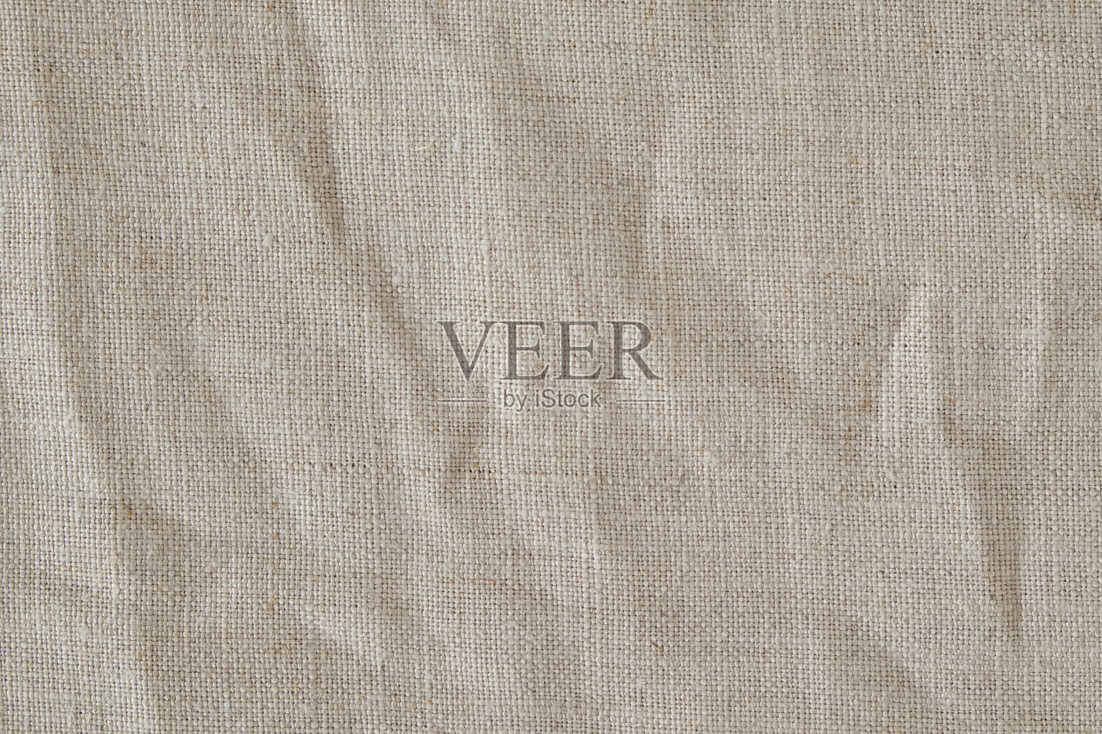 褶皱米色棉麻织物纹理背景,细节特写,质朴皱皱的复古织物。照片摄影图片