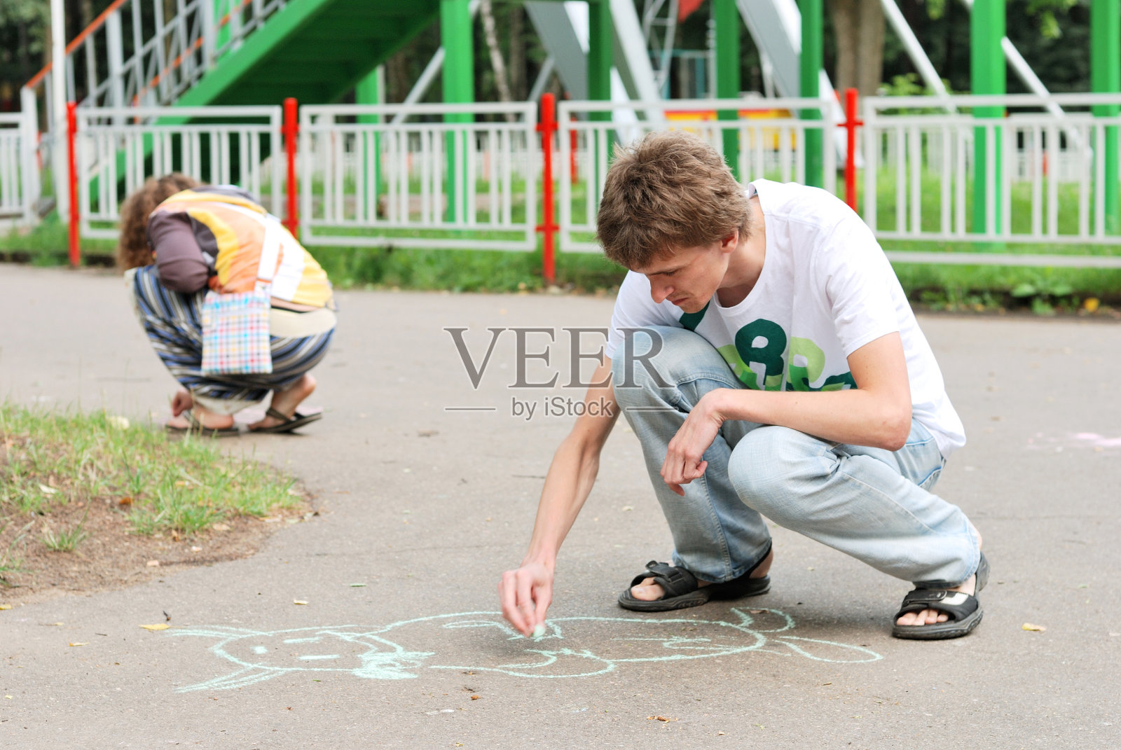 年轻男女在柏油路上作画照片摄影图片