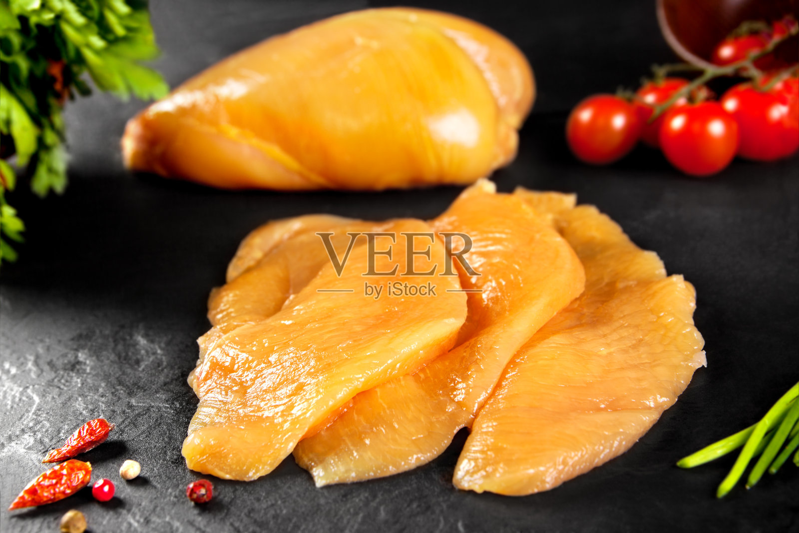 新鲜的生肉。切成小块供烹调用的鸡胸肉照片摄影图片