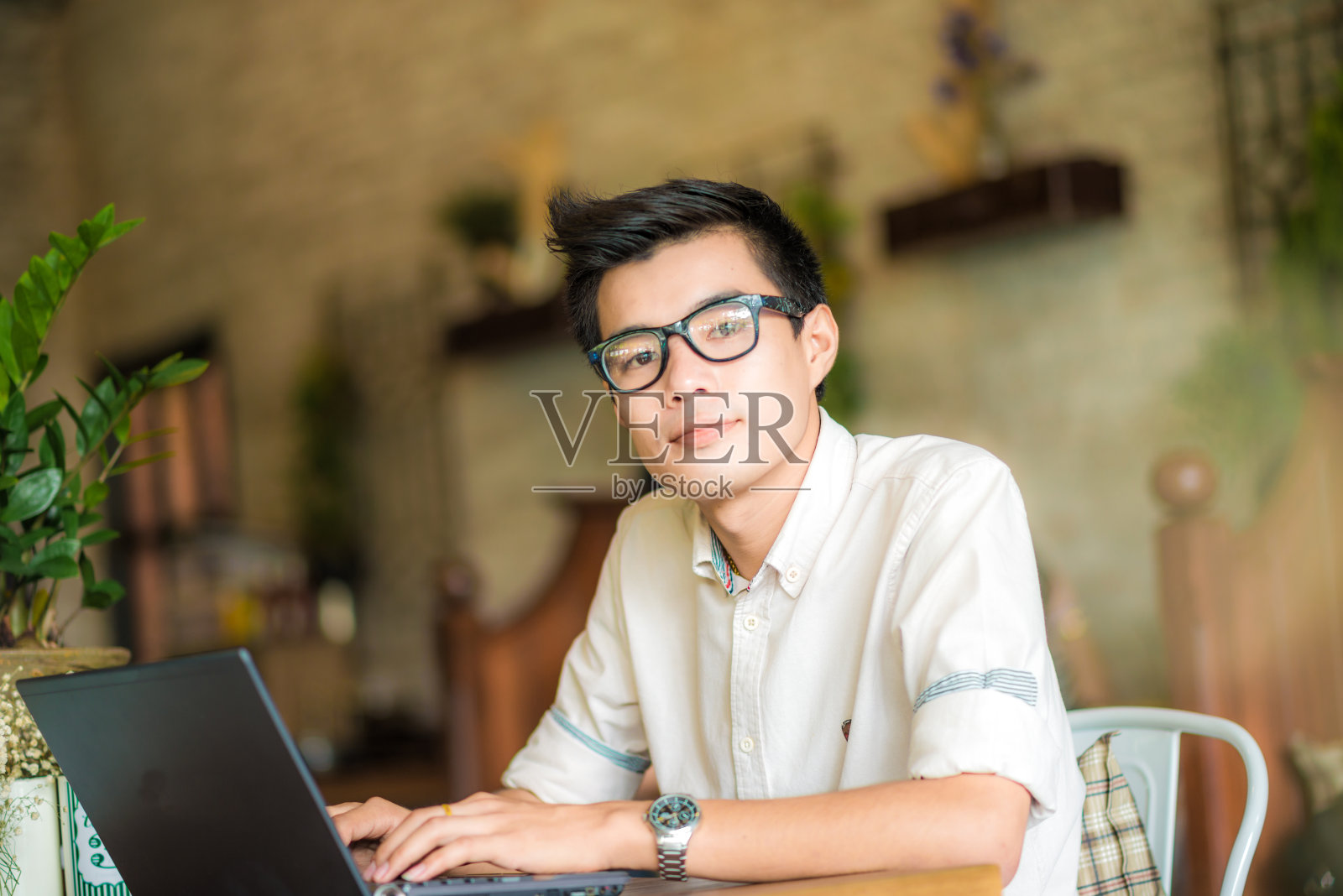 年轻的亚洲学生在咖啡馆里使用平板电脑照片摄影图片