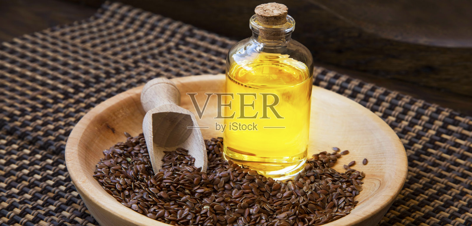 亚麻籽油瓶,富含Omega-3健康脂肪的籽油与木盘中的亚麻籽照片摄影图片