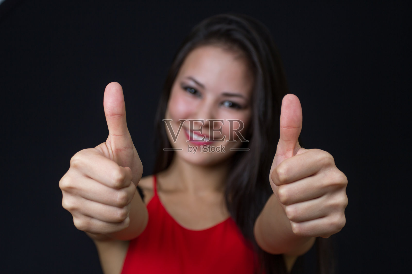 年轻的亚洲女孩竖起大拇指照片摄影图片