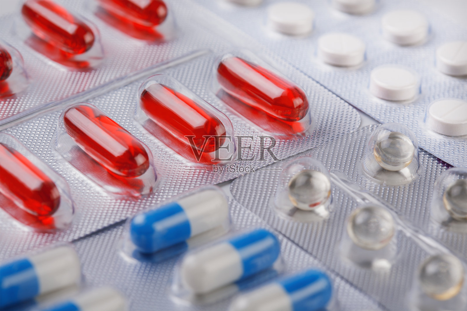 红色的维生素丸和其他药丸装在塑料袋里照片摄影图片
