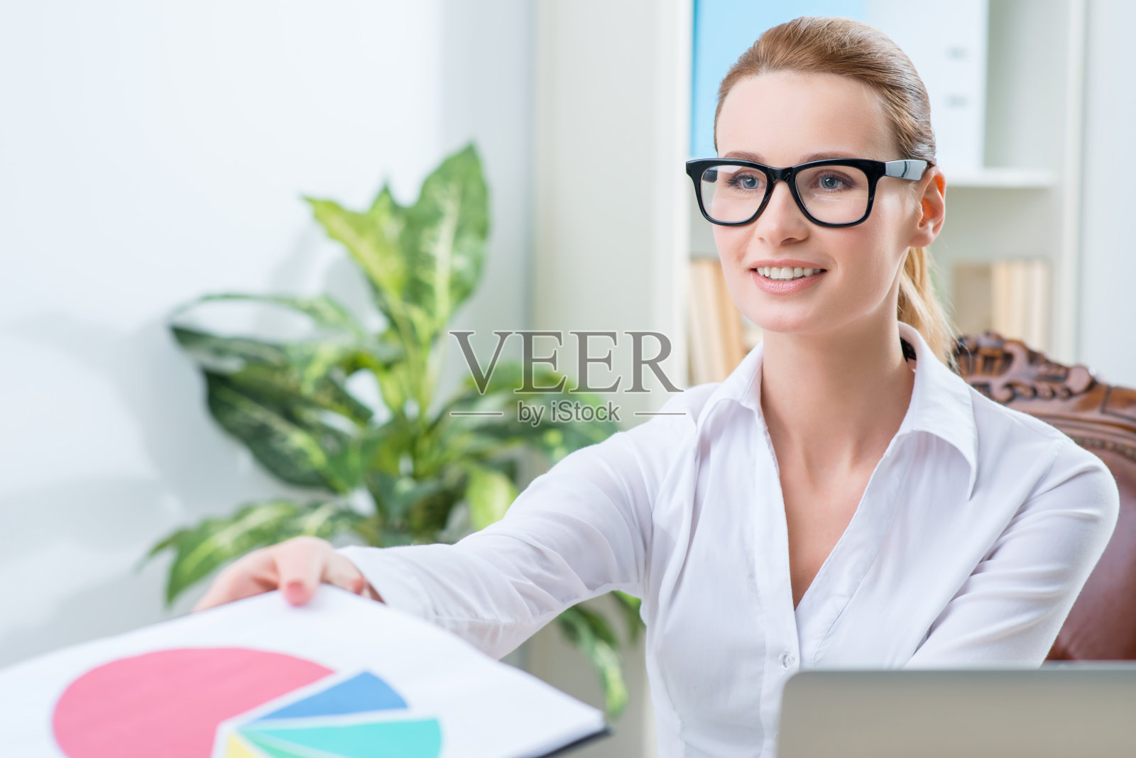 愉快的办公室职员坐在桌旁照片摄影图片