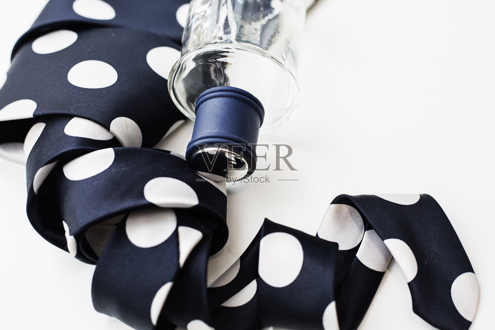 一瓶男士香水,白色背景上系着领带。照片摄影图片