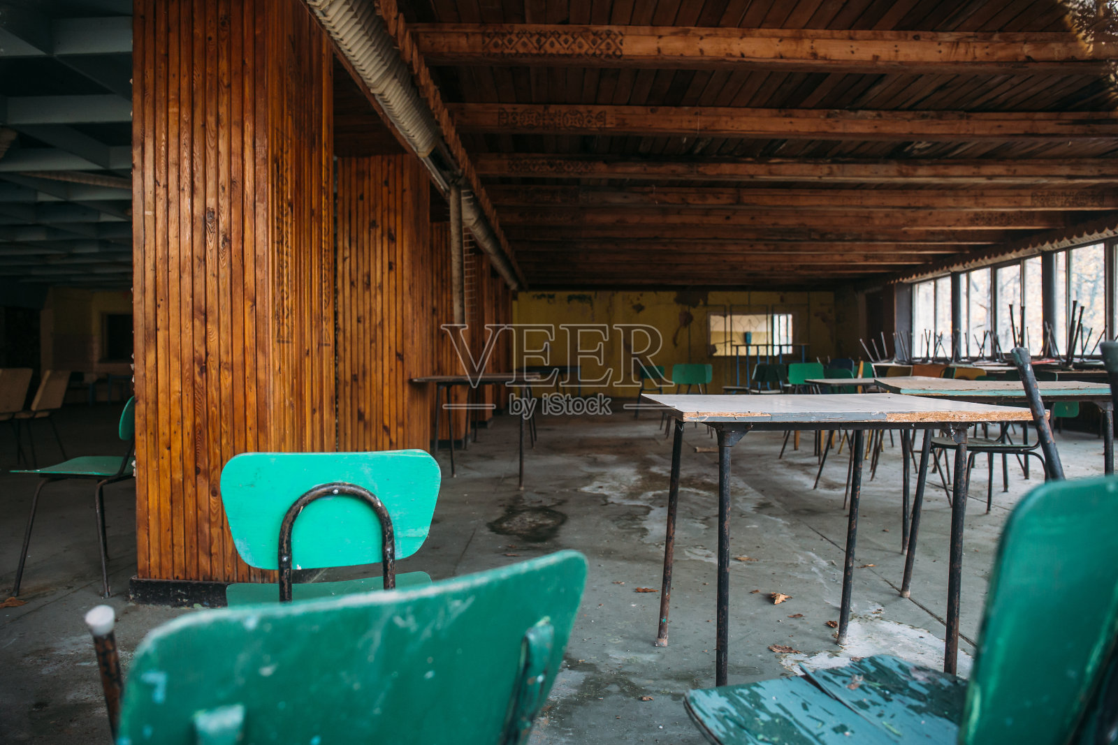 废弃建筑内部,配有桌椅的大型餐厅照片摄影图片