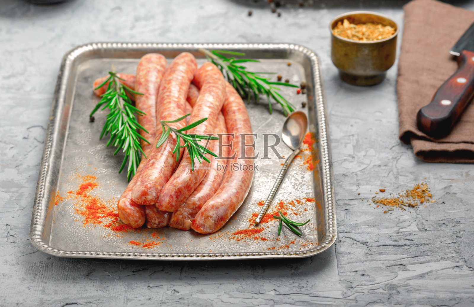 生香肠放在托盘上烤,配上香料照片摄影图片