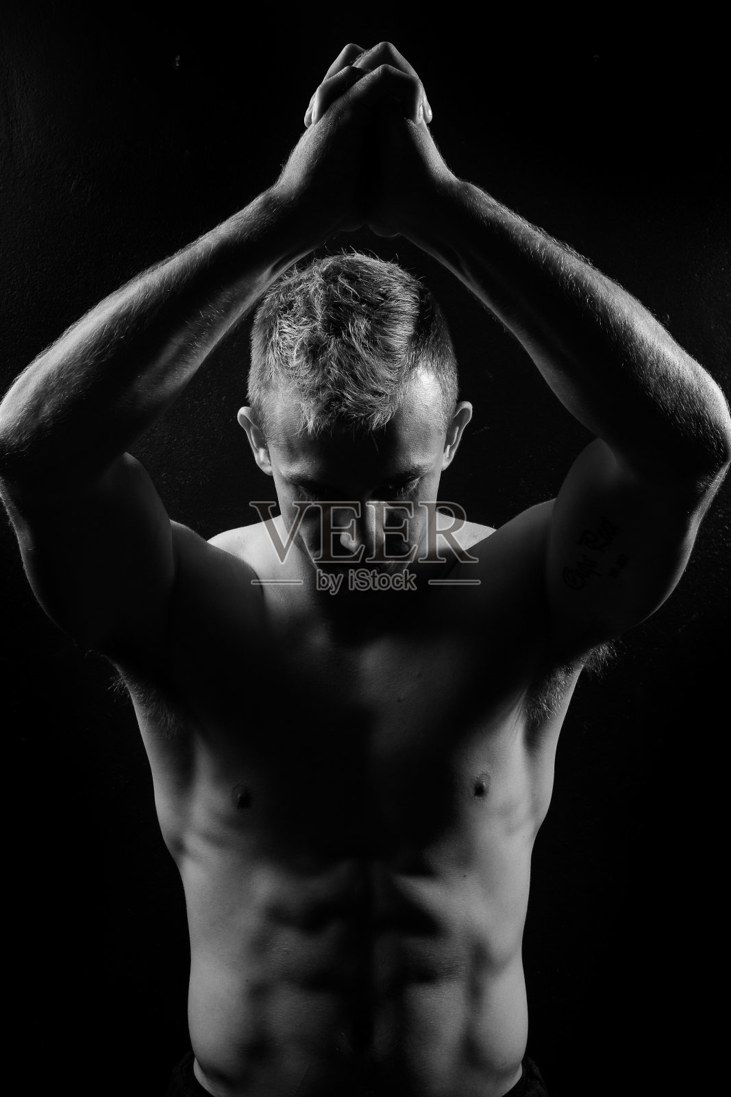 男性健身模型显示肌肉在工作室与黑色背景照片摄影图片