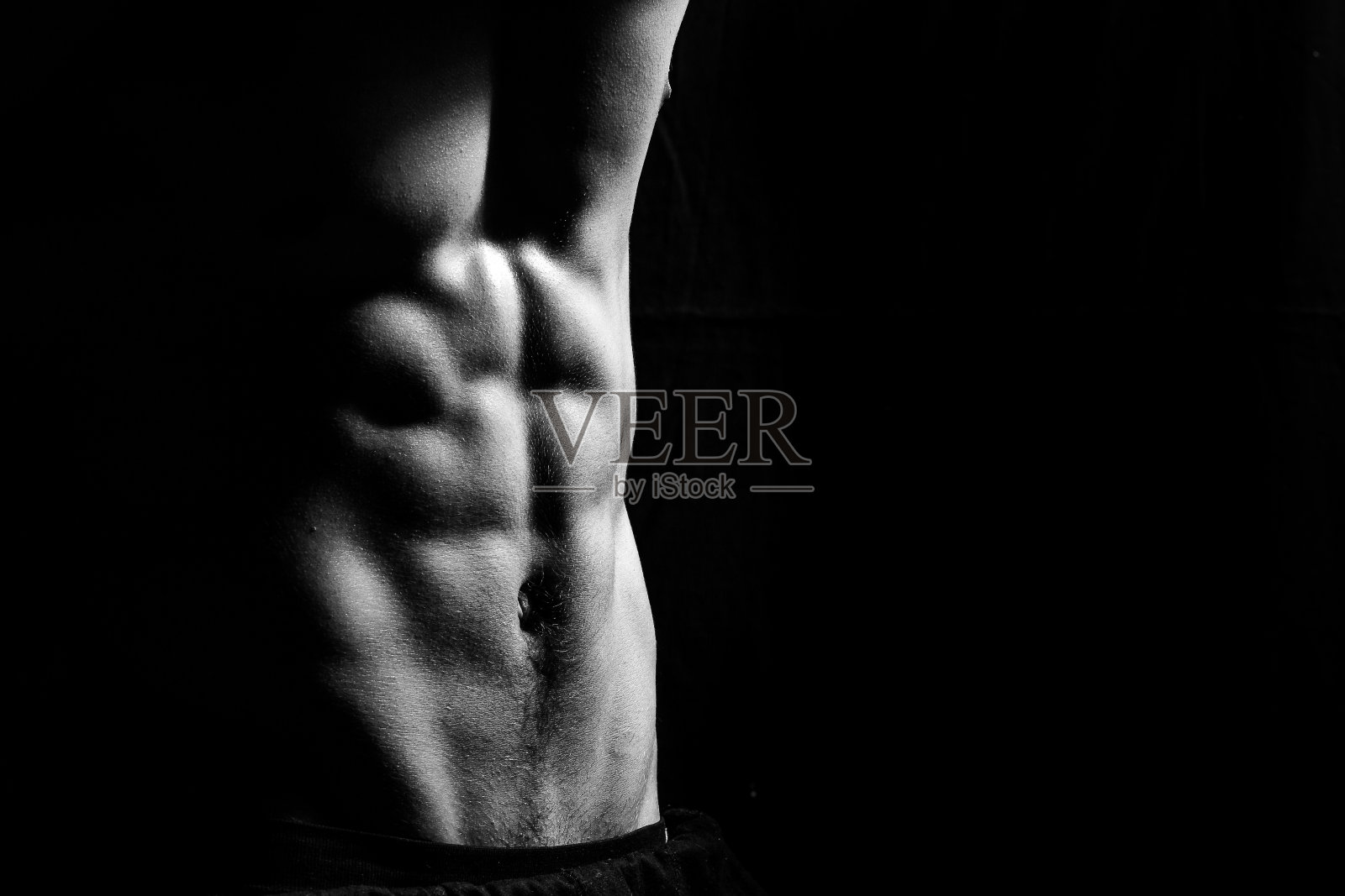 男性健身模型显示肌肉在工作室与黑色背景照片摄影图片