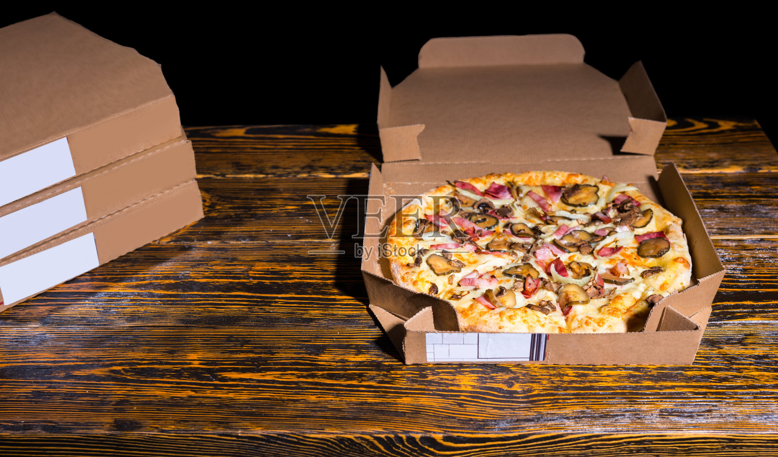 有火腿、蘑菇、洋葱和泡菜的披萨照片摄影图片