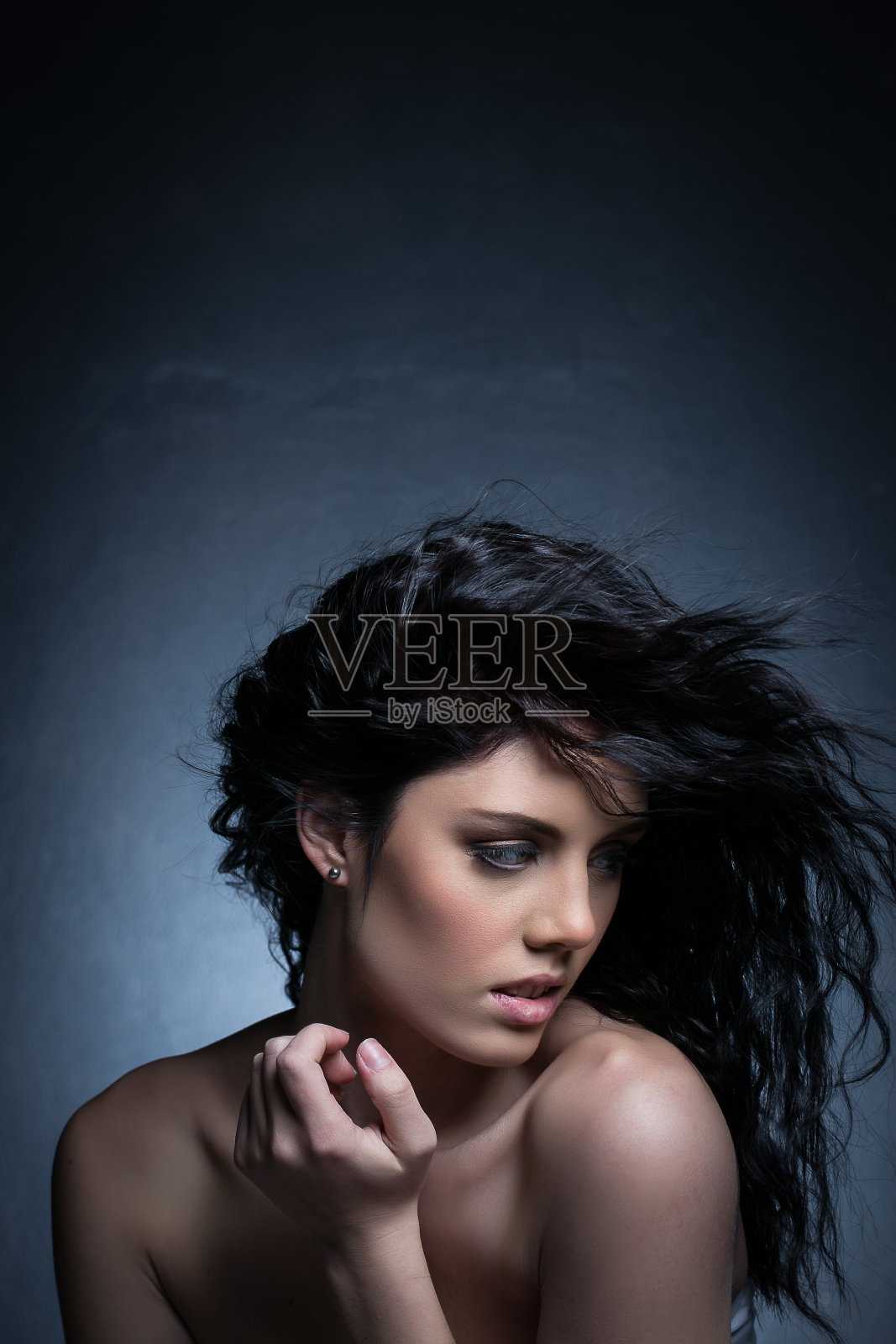 一个深色背景的工作室里的黑发女模特照片摄影图片