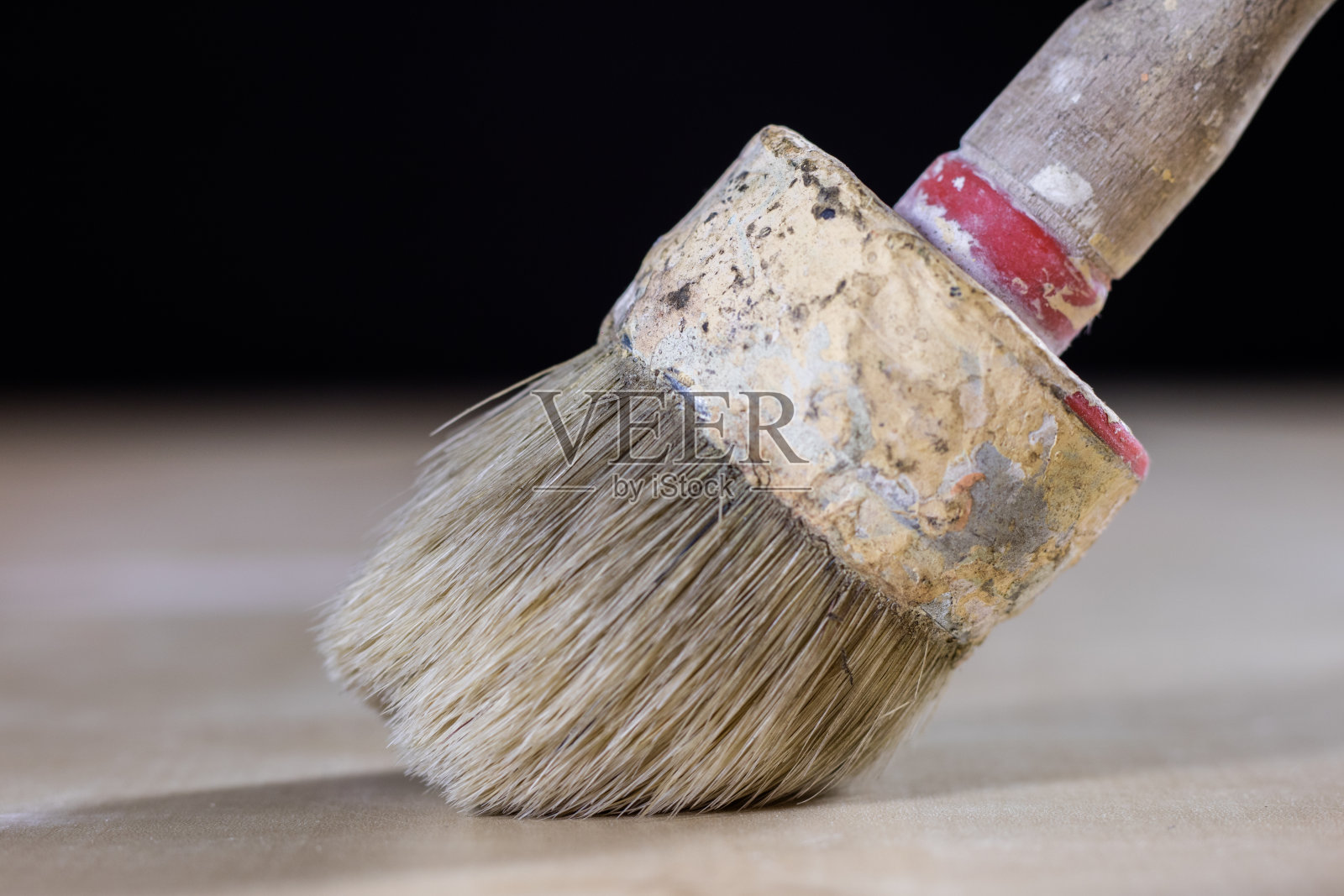 油漆用的旧刷子,木桌上的油漆罐。喷漆车间。黑色背景照片摄影图片