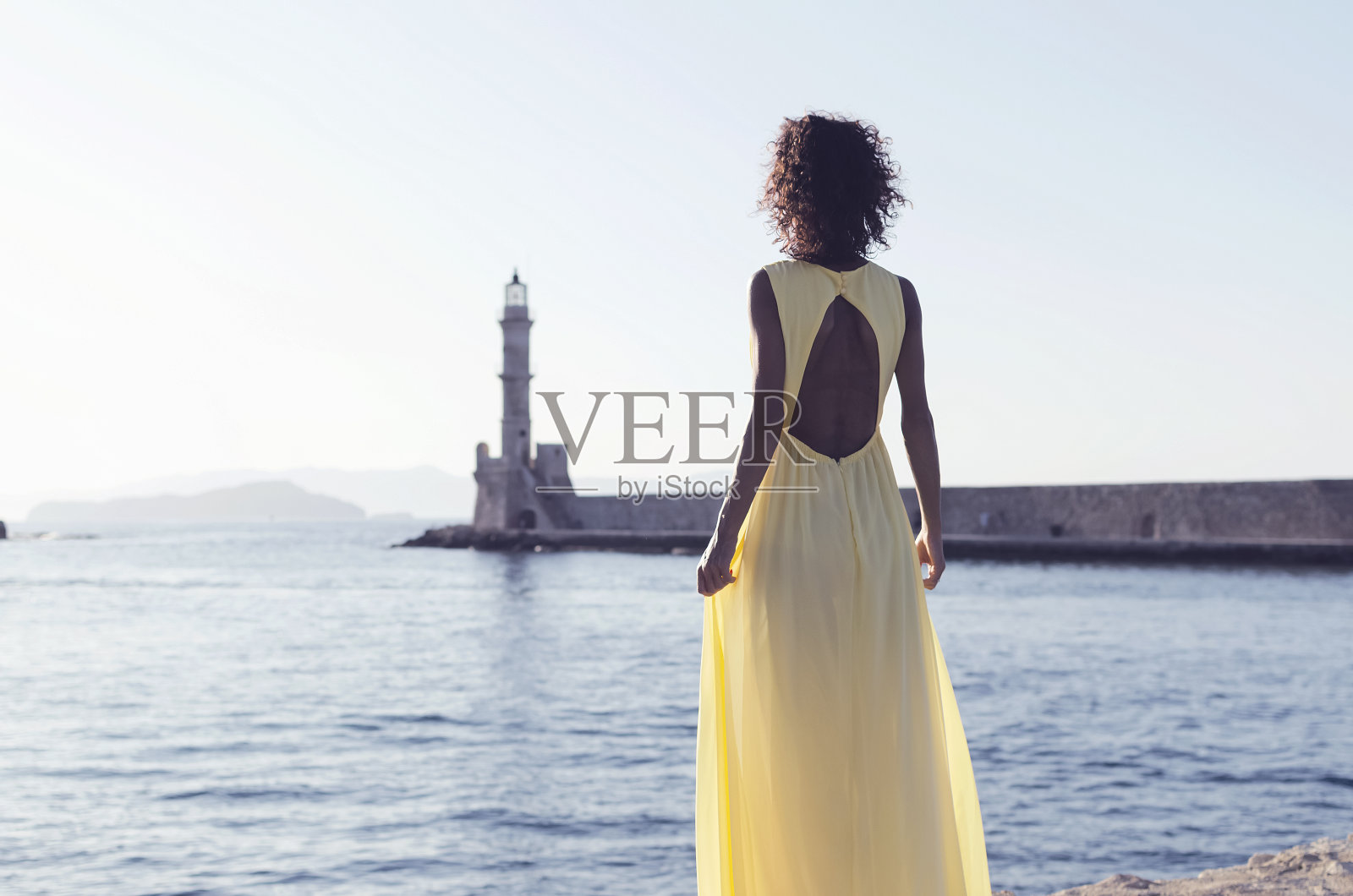 女人望着大海和灯塔照片摄影图片