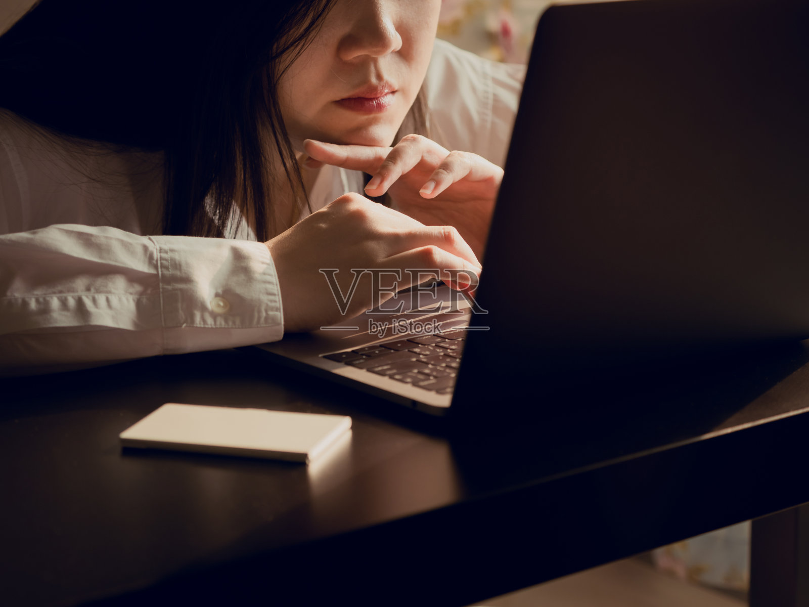 正面从美丽的亚洲商务女性(30岁到40岁)与白衬衫感觉疲倦和严重后使用电脑笔记本电脑支持她的业务与软焦点背景照片摄影图片