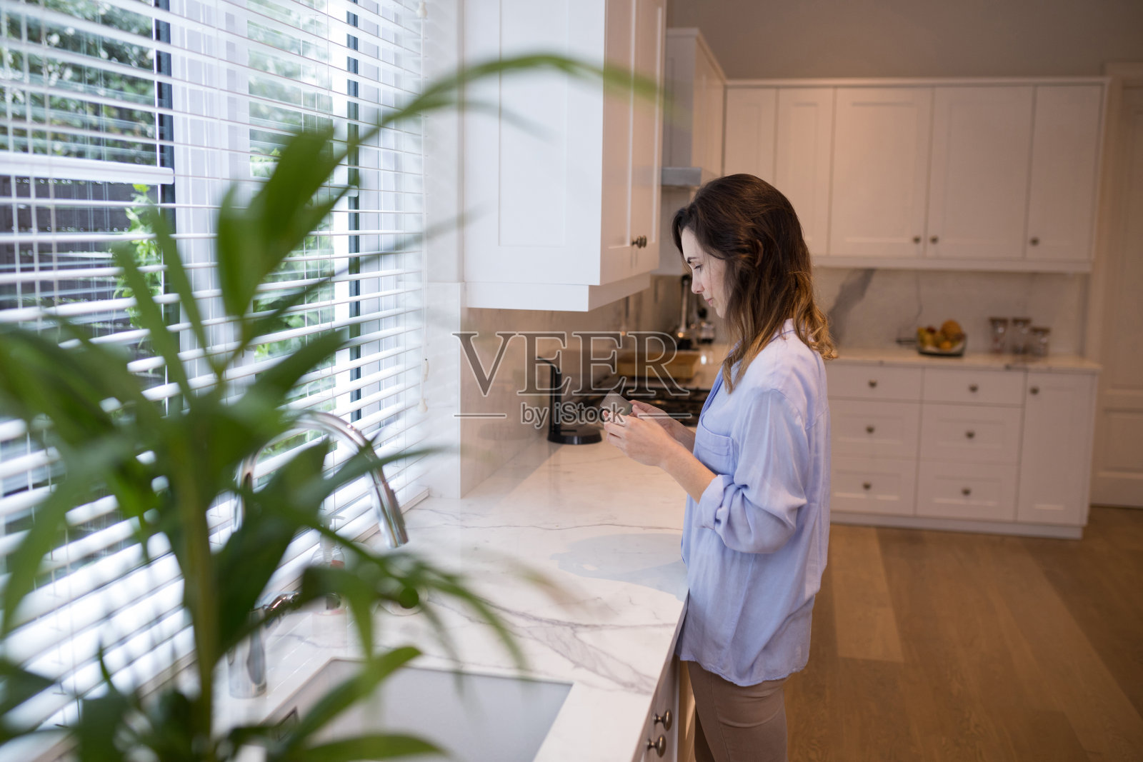 体贴的女人站在厨房里照片摄影图片