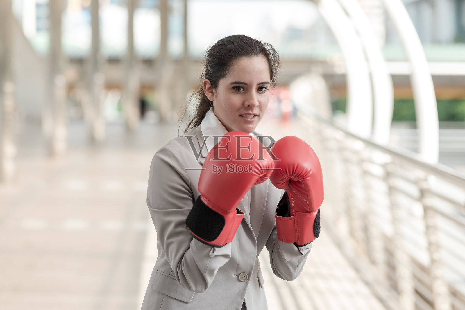 戴拳击手套的女商人。照片摄影图片