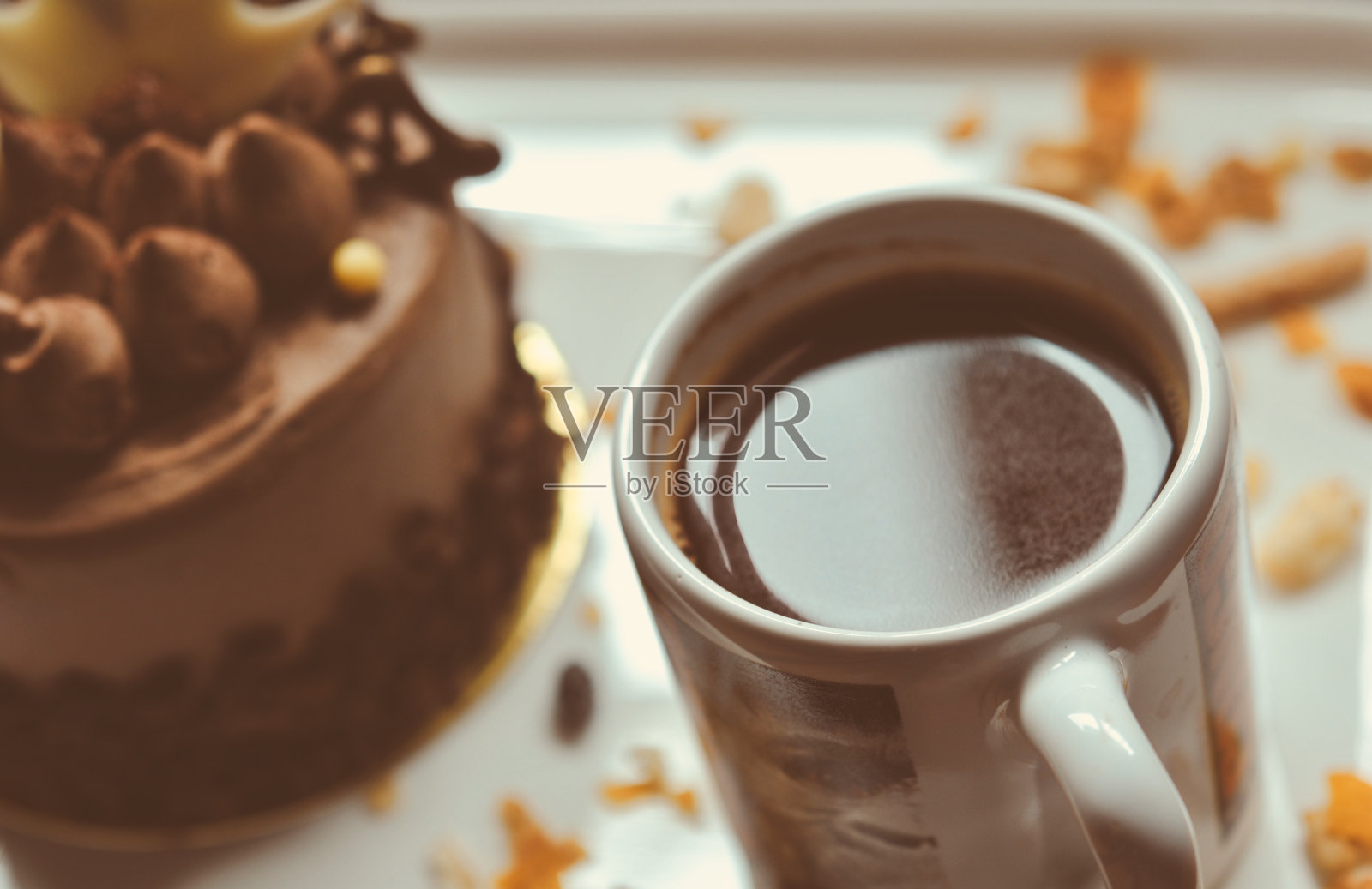 白色盘子上的巧克力蛋糕配上一杯咖啡,食物微缩摄影装饰理念为新年晚会。照片摄影图片