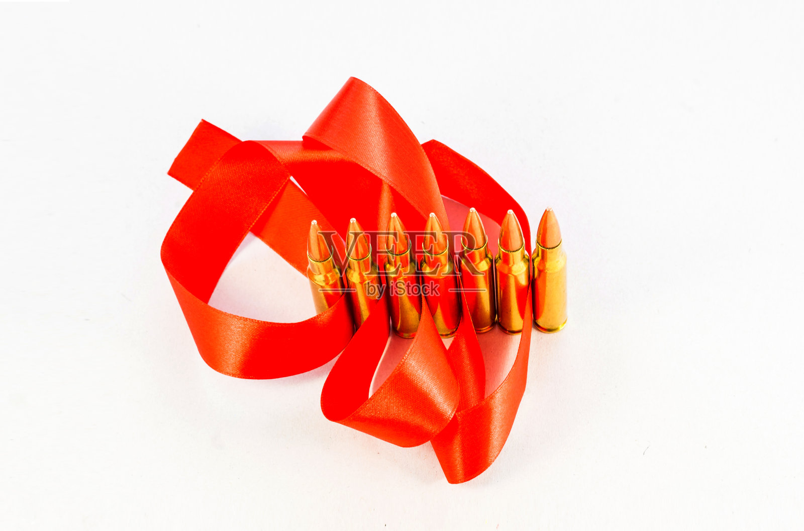 步枪子弹。铜套。用红丝带。在白色的背景上照片摄影图片