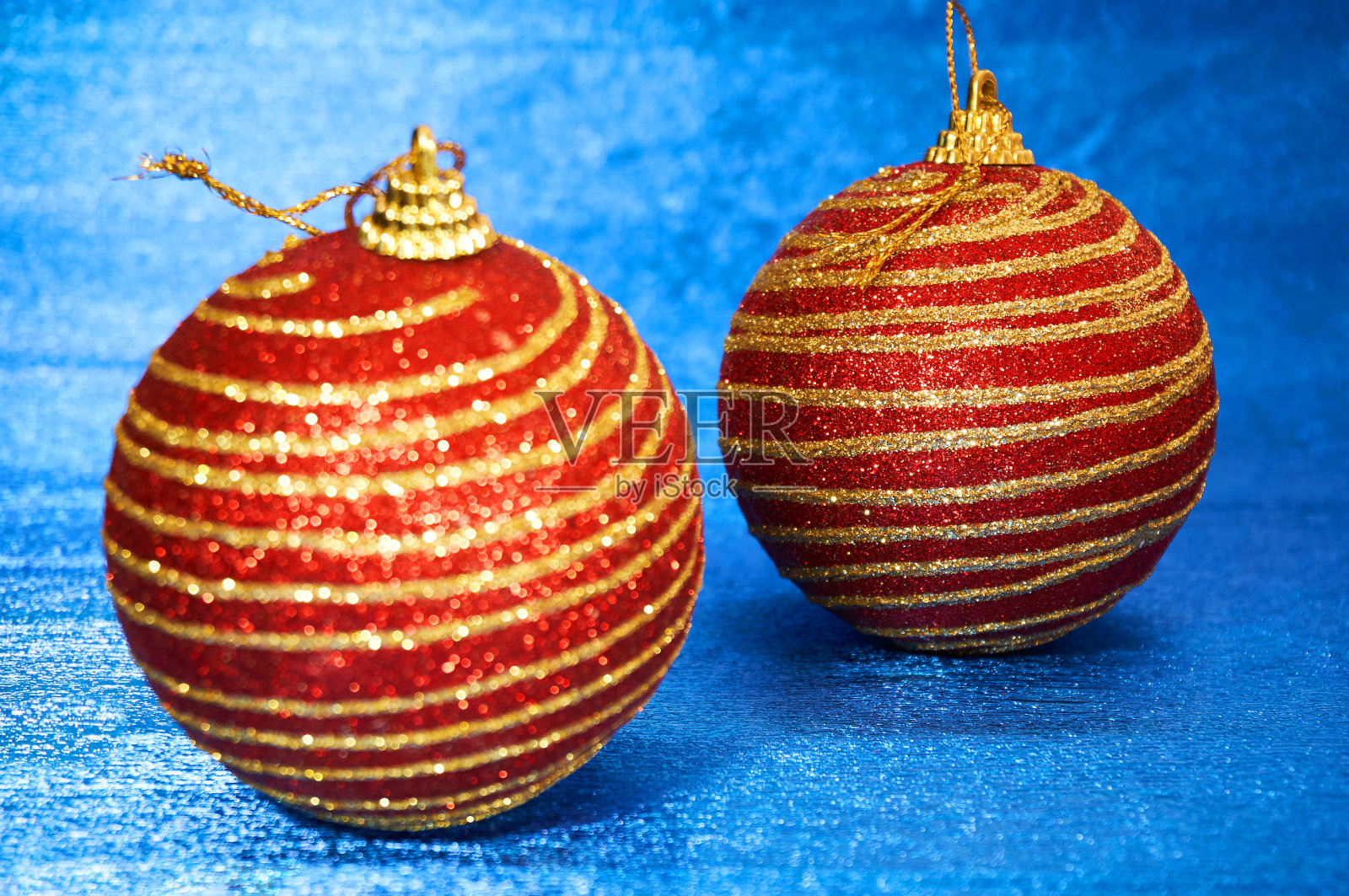 红色圣诞玩具与金色条纹的蓝色背景特写。新年,圣诞背景。照片摄影图片