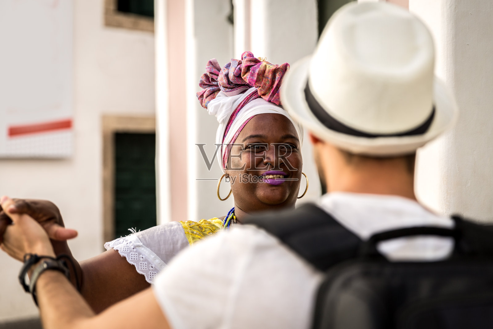 在巴西巴伊亚州萨尔瓦多的Pelourinho,游客与“Baiana”女子跳舞照片摄影图片