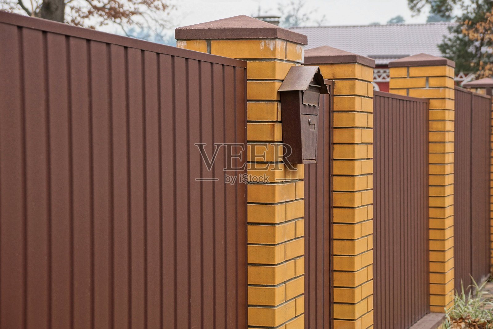 街道上有一个邮箱的棕色篱笆照片摄影图片