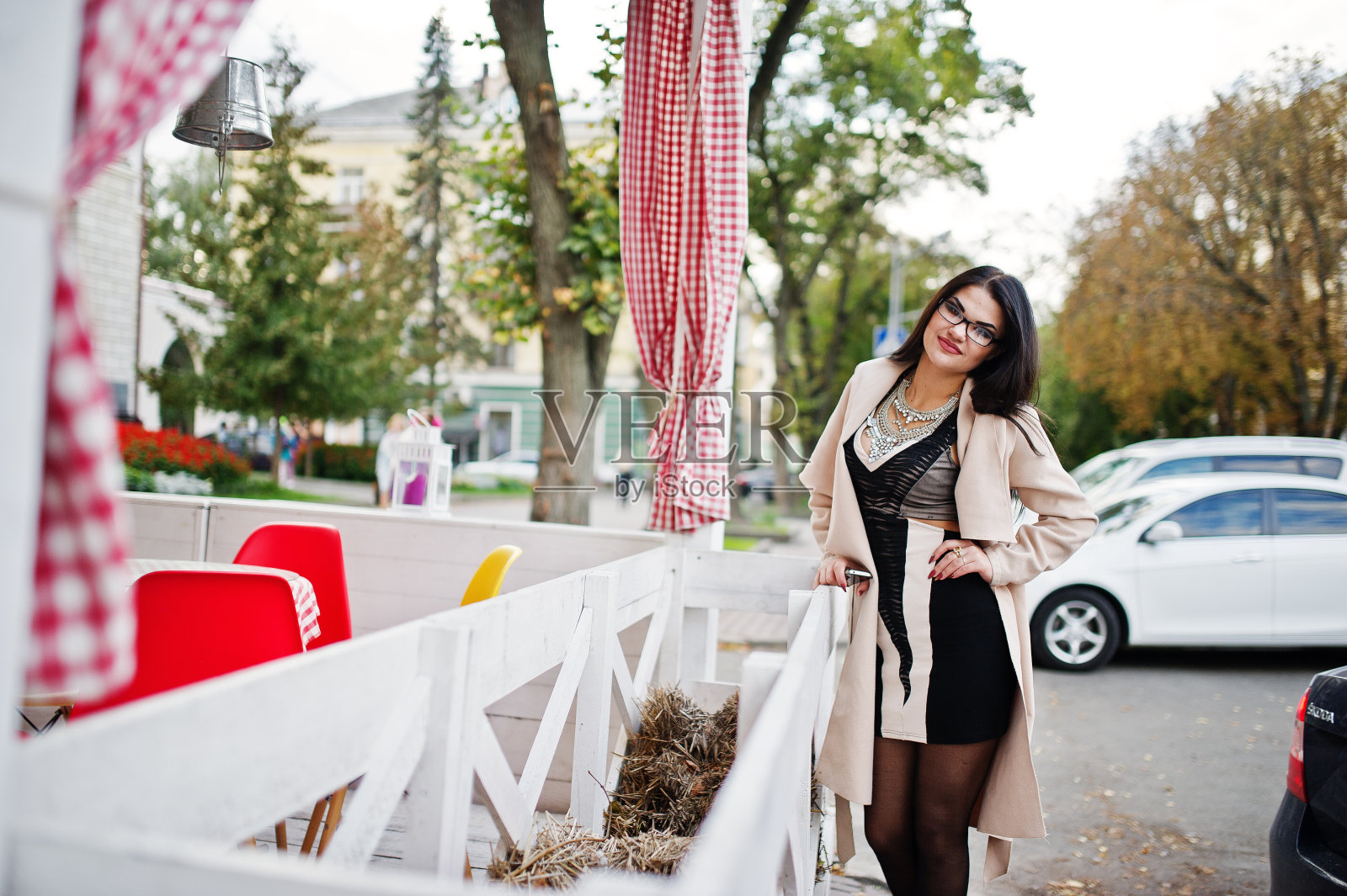 戴眼镜穿外套的黑发女人摆好姿势照片摄影图片