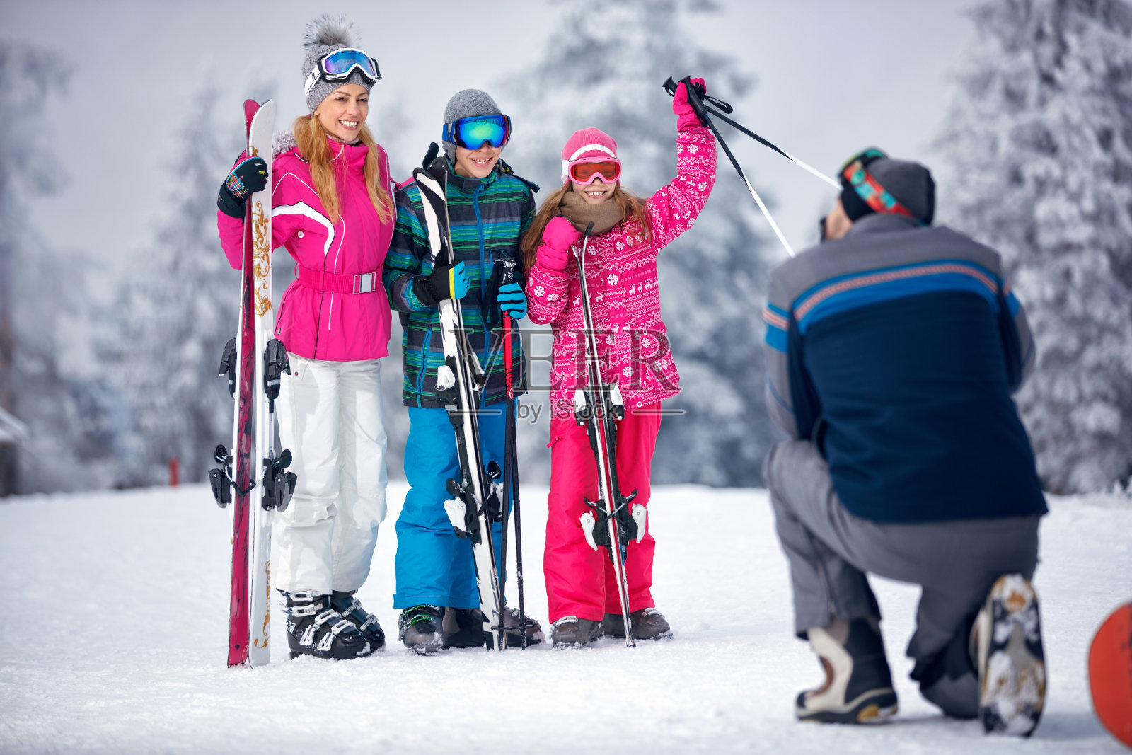 滑雪,雪太阳和乐趣-父亲拍照的家庭在雪照片摄影图片
