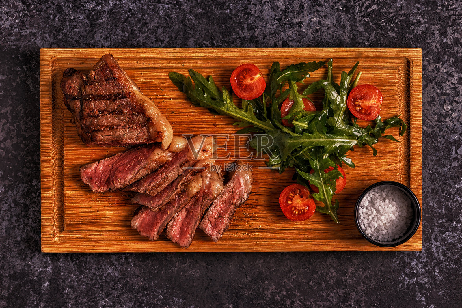 深色背景上的牛排。照片摄影图片