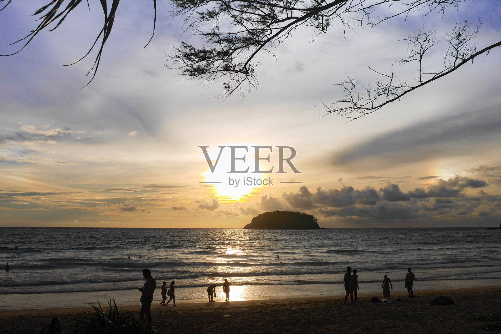 泰国普吉岛——2017年9月13日——在卡塔海滩,游客们在做日光浴、阅读、游泳、拍照、看日落等活动。多云的天空是岛屿的亮点。照片摄影图片