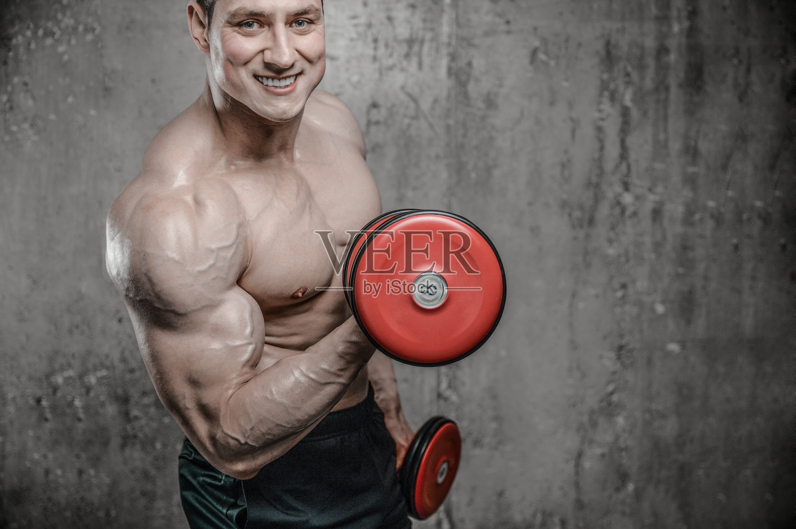 英俊的模特年轻男子在健身房训练手臂照片摄影图片