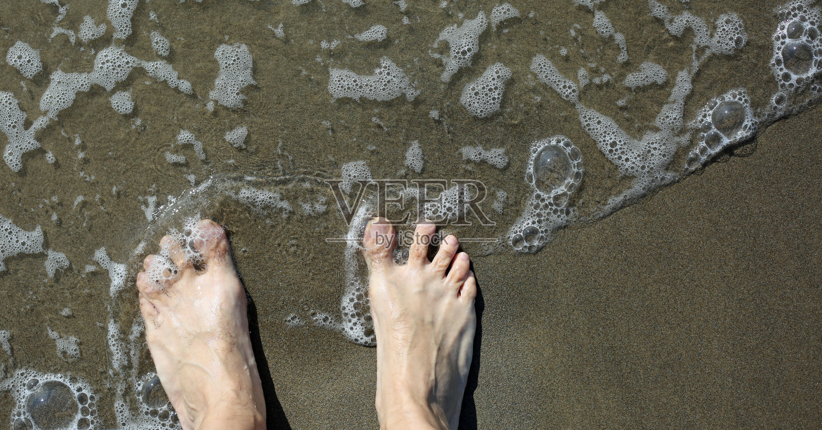 两只脚光着脚的成年人在海边和海浪上照片摄影图片