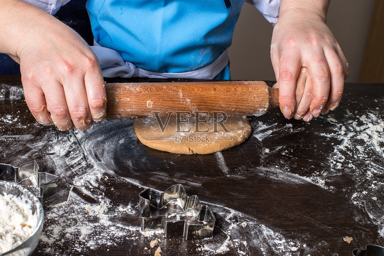 小女孩的手用擀面杖擀面团照片摄影图片