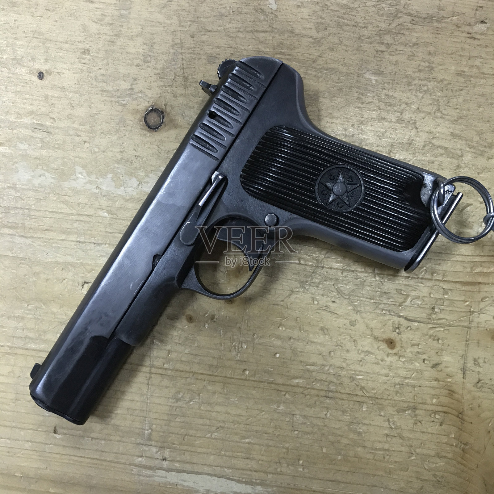 那把旧TT枪放在一张木桌上。照片摄影图片