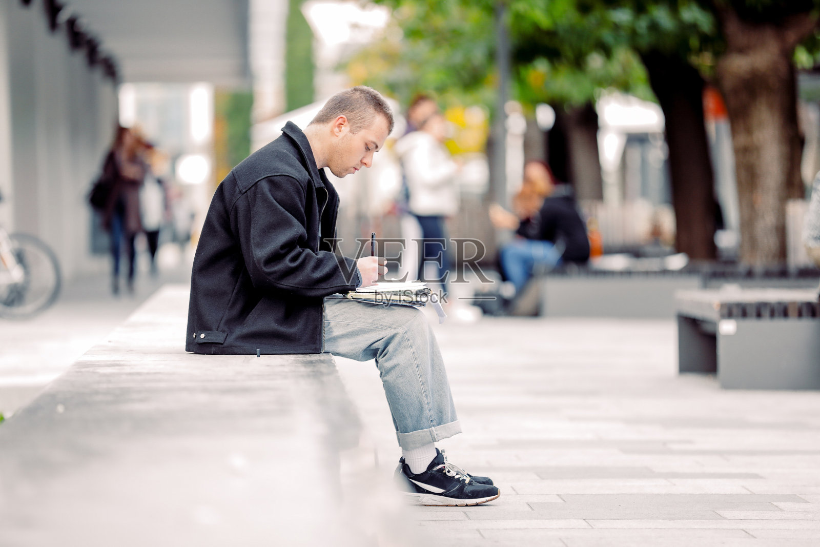 年轻的涂鸦艺术家在城市街道上素描照片摄影图片