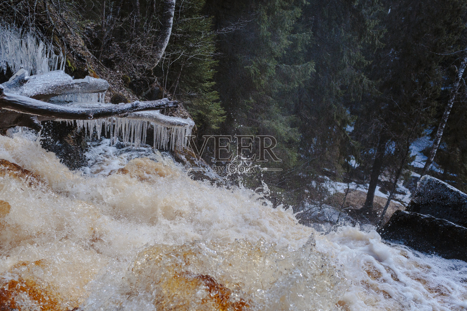 冰冻树木背景下的沸腾瀑布照片摄影图片