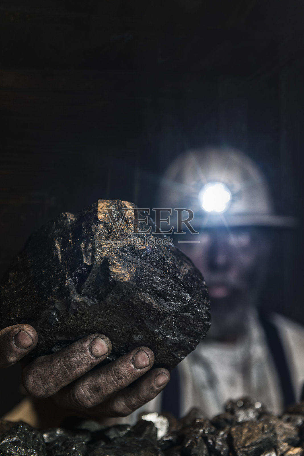 一名矿工被一大块无烟煤覆盖在煤尘中照片摄影图片