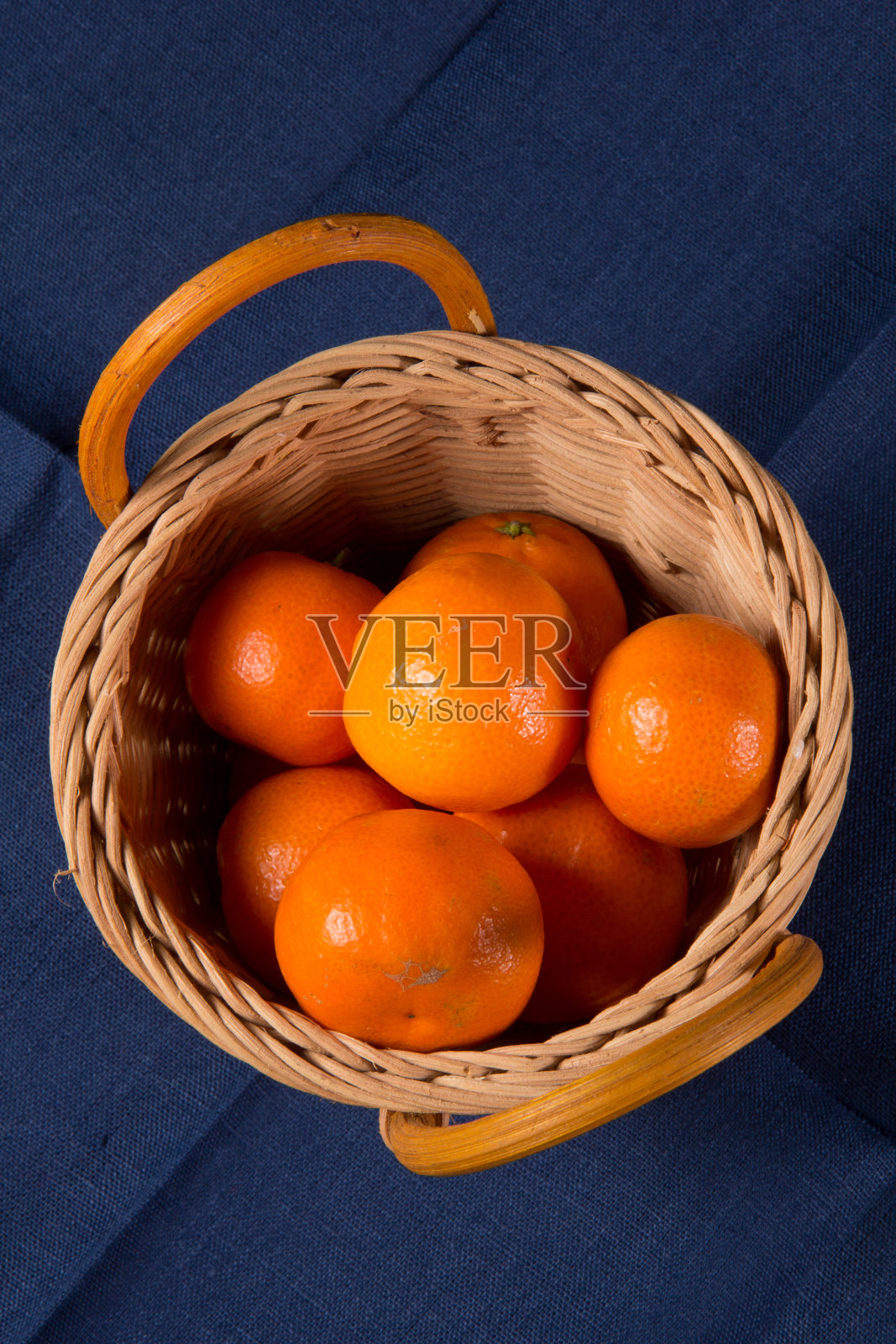 蓝色的亚麻布餐巾上放着成熟的橘子照片摄影图片