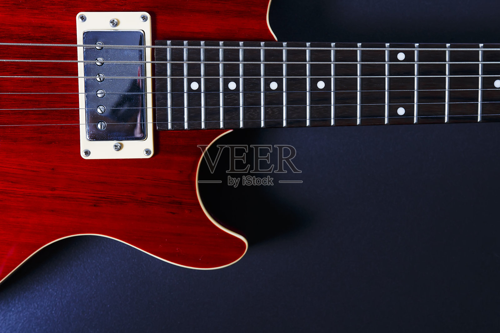 红色电吉他上的黑色背景特写。音乐的概念。照片摄影图片