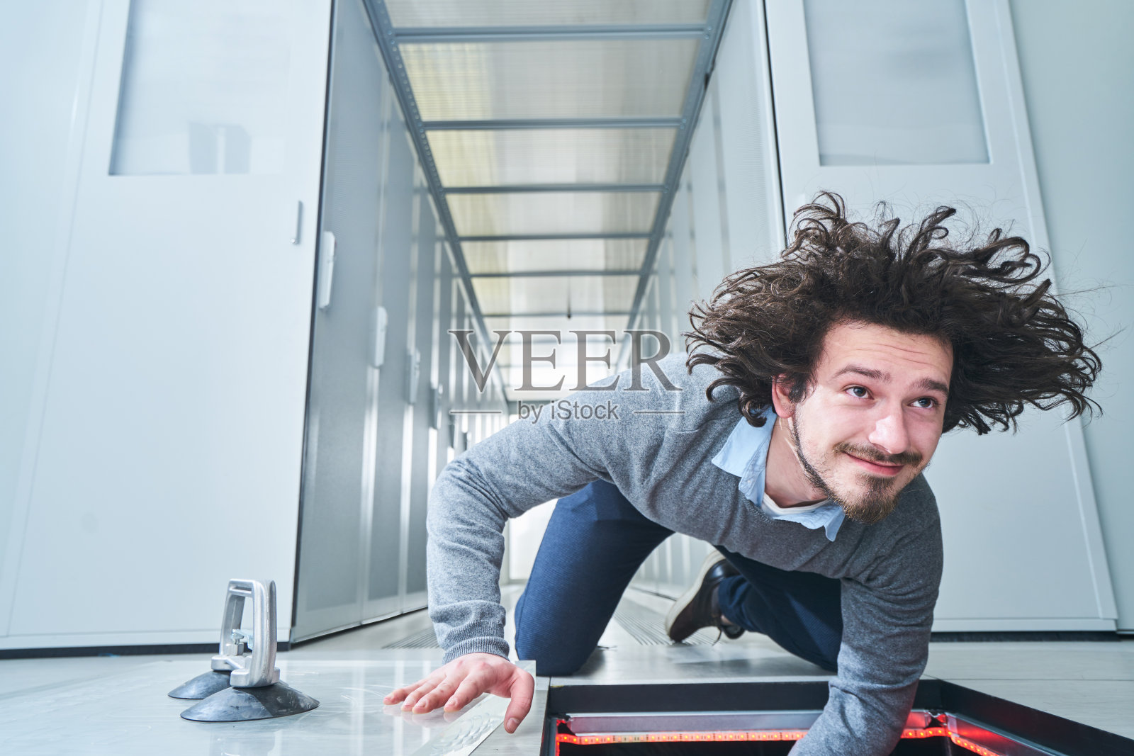 一个年轻人在舱口修东西。数据中心。服务器照片摄影图片