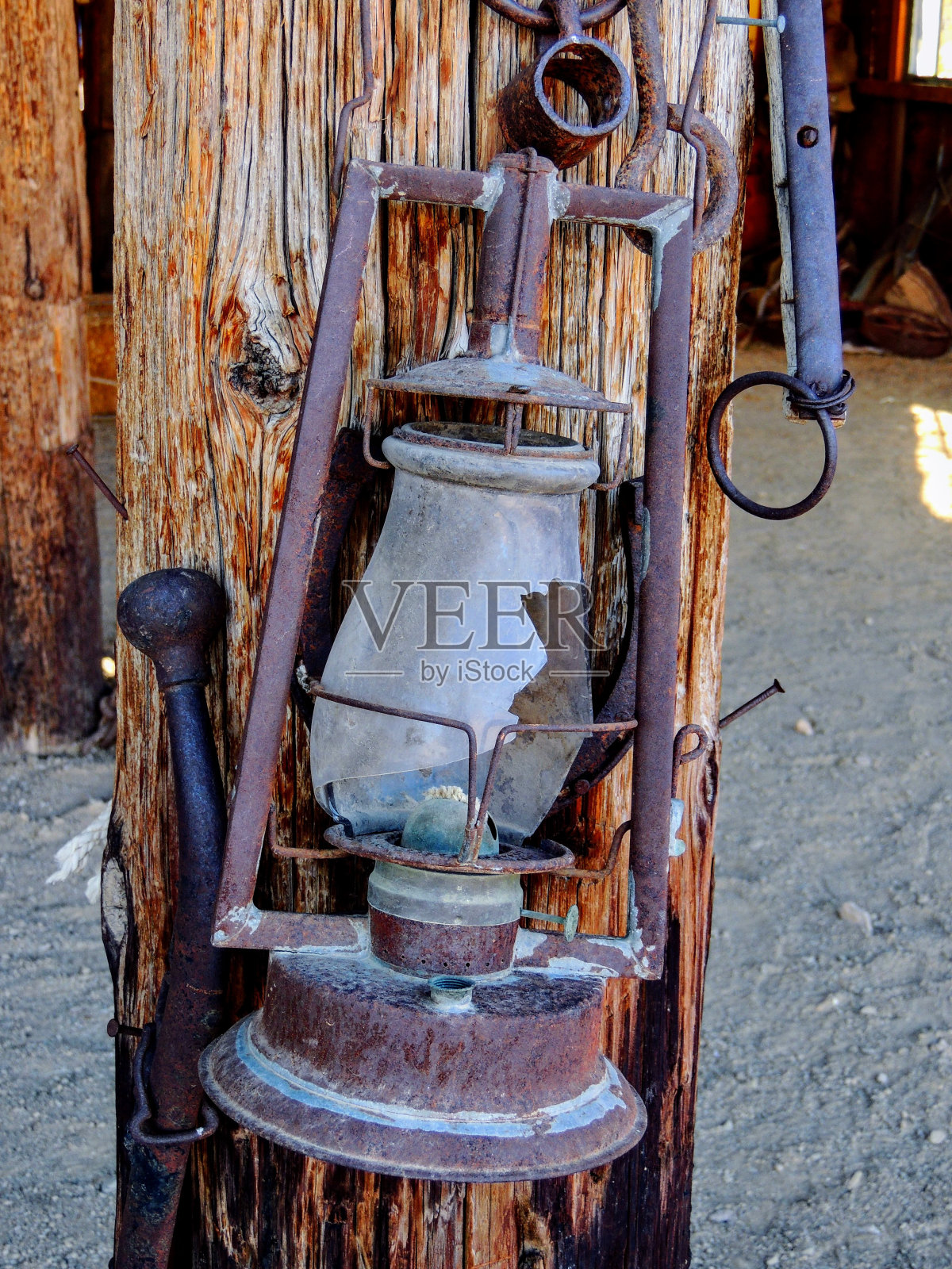 西洋风格的锈迹古色古香的破油灯挂在农家乡野的老灯复古的木头背景上。照片摄影图片